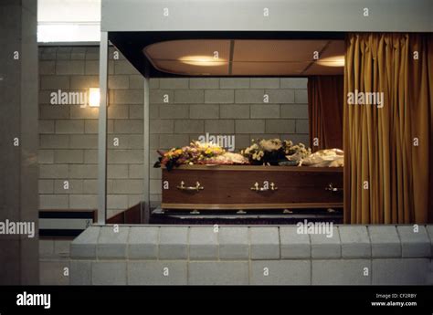 coffin laid with flowers behind glass in a crematorium Stock Photo ...