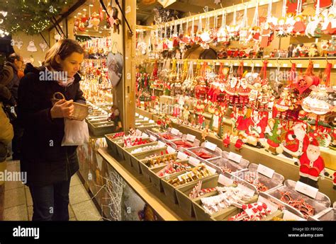 A woman shopping at an Xmas stall, Strasbourg Christmas Market, Strasbourg, Alsace, France ...