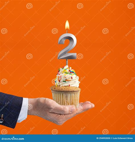 The Hand that Delivers Cupcake with the Number 2 Candle - Birthday on Orange Background Stock ...