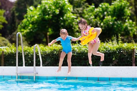 Kids jumping into swimming pool — Stock Photo © FamVeldman #119853634