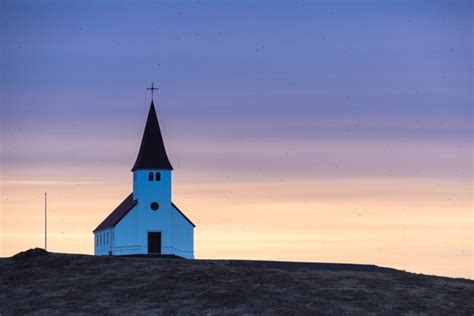 Premium Photo | Purple and orange sunrise over vik church in iceland on ...