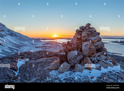 Polar arctic greenlandic sunset over the Nuuk fjord and stone pyramid ...