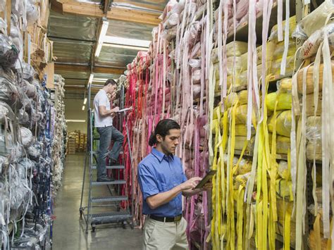 Workers examining fabric in textile factory stock photo