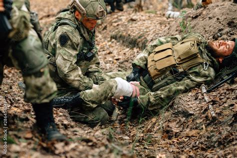 Bandaging a wounded soldier. A group of soldiers in defense of their ...