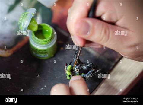 Close up of a man painting a Warhammer Squig Hog Boy with green paint (orruk flesh Stock Photo ...