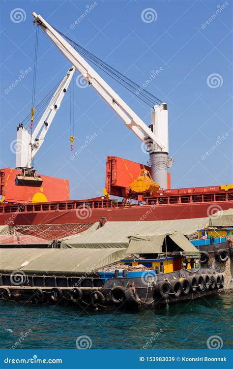 Loading Wheat on Cargo Ship with Crane and Bucket. Shipment from a Merchant Ship To a Small Ship ...