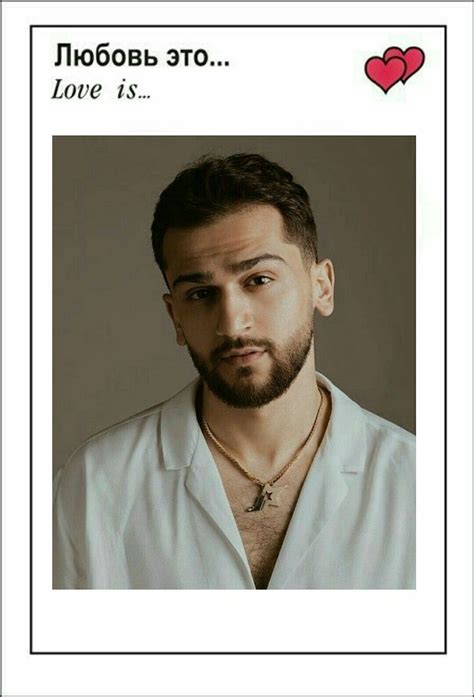 a man with a beard wearing a white shirt and looking at the camera while standing in front of an ...