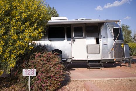 An Airstream trailer puts down stakes for a spell amid showy blooms at Desert's Edge RV Park in ...