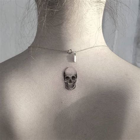 Human skull tattoo on the upper back.