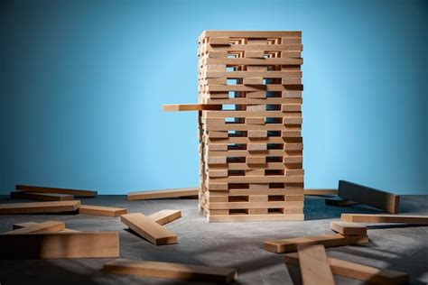 Premium Photo | Jenga game, a tower of wooden blocks on blue