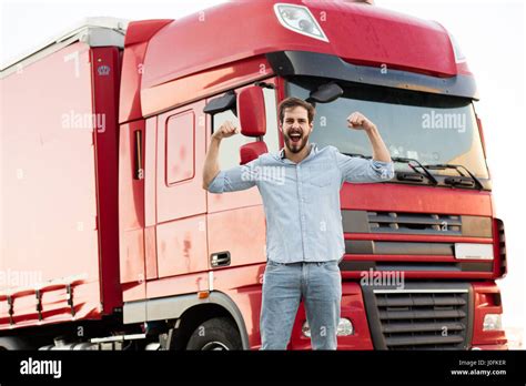 strong masculine truck driver standing outside and showing his muscle ...