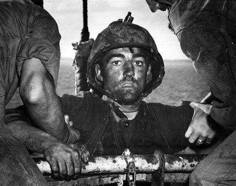 “The Thousand Yard Stare”—USMC Private Theodore J. Miller is helped aboard a ship after intense ...