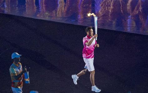 Lin Dan holding the torch and marches to the stadium at the Nanjing Youth Olympic Games Opening ...