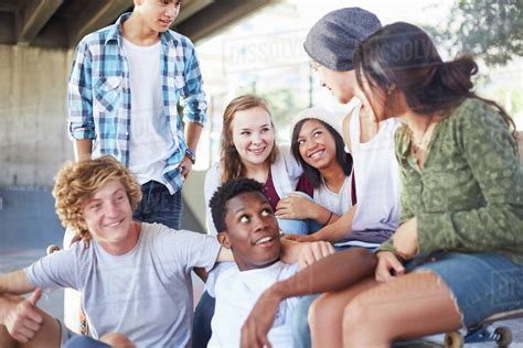 Teenage friends hanging out talking at skate park - Stock Photo - Dissolve