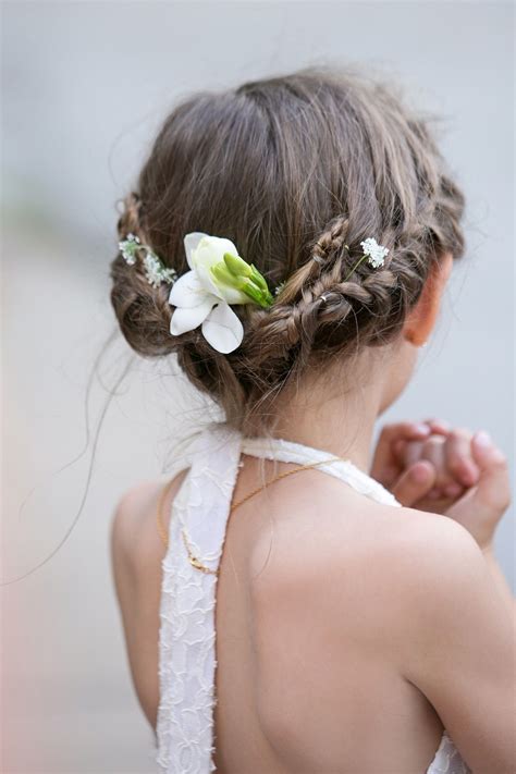 After rolling up all the hair, this girl's stylist tucked in fresh baby blooms and a budding ...