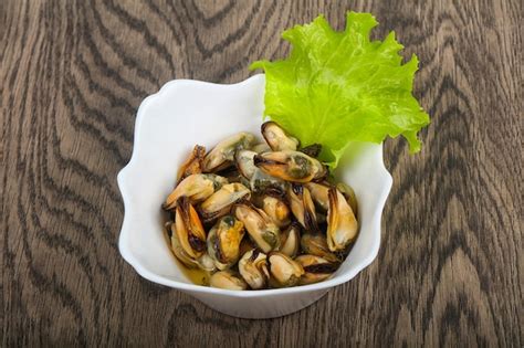 Premium Photo | Pickled mussels with salad leaves