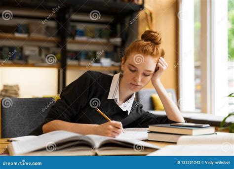 Image of Smart Teenage Girl Studying, while Sitting at Desk in C Stock ...