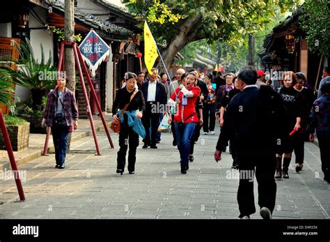 LANGZHONG ANCIENT CITY (SICHUAN), CHINA: Tour guide with her yellow ...