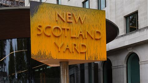 New Scotland Yard sign covered with yellow paint as protesters target Metropolitan Police HQ ...