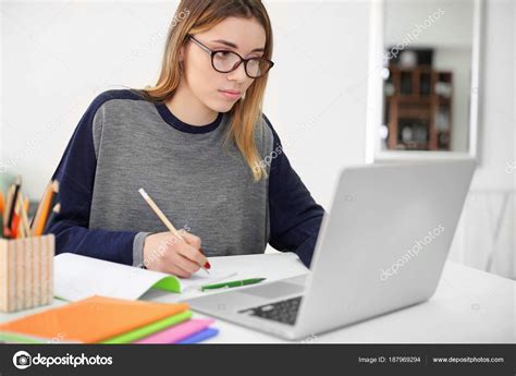 Pretty student with laptop studying at table indoors Stock Photo by ©belchonock 187969294