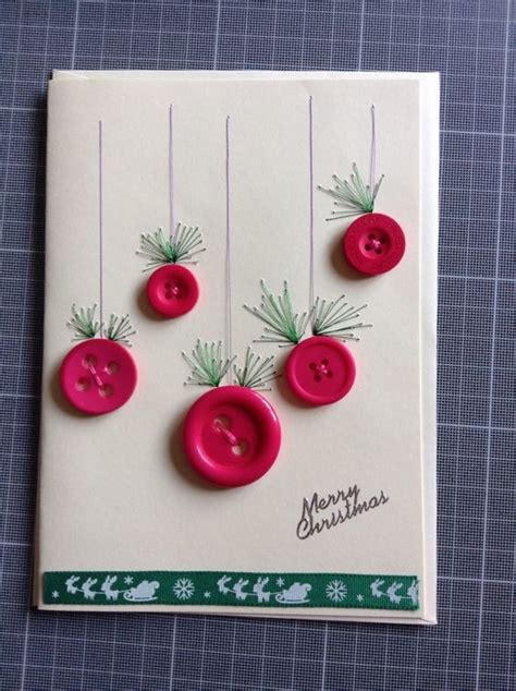 four pink buttons are hanging on a white card with green needles and ...