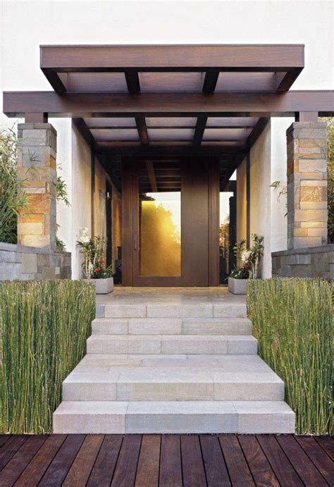 an entry way with steps leading up to the door and grass growing on the side