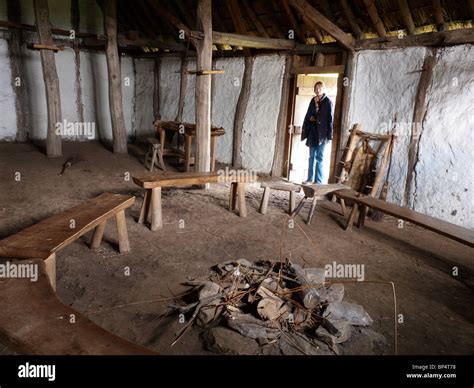 A woman at the door of medieval farm house interior at The Museum of Early Medieval Northumbria ...