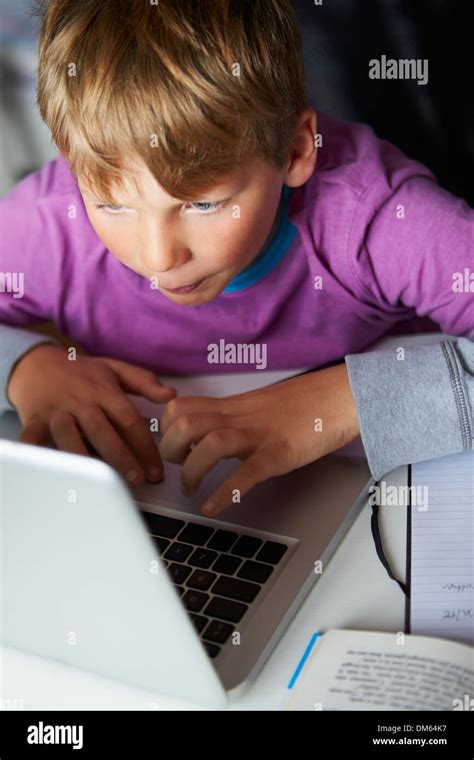 Boy Studying In Bedroom Using Laptop Stock Photo - Alamy