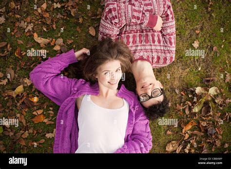 Teenage couple laying in grass in park Stock Photo - Alamy