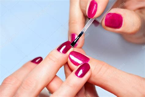 Mujer aplicando barniz de uñas a las uñas de los dedos: fotografía de ...