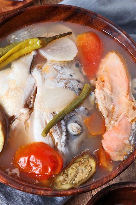 a wooden bowl filled with fish and vegetables