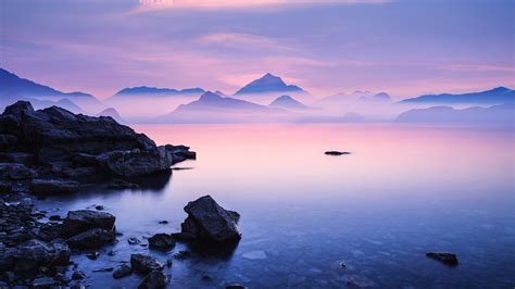 Sunset on a sea rocky beach, pink mountains | Windows Spotlight Images