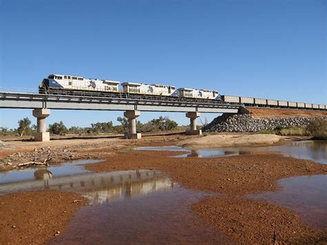 Fortescue Metals Group (FMG) 2.6km long, empty iron ore train crossing the Turner River in the ...