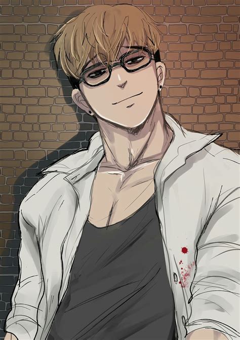 a man with glasses and a white jacket is sitting in front of a brick wall