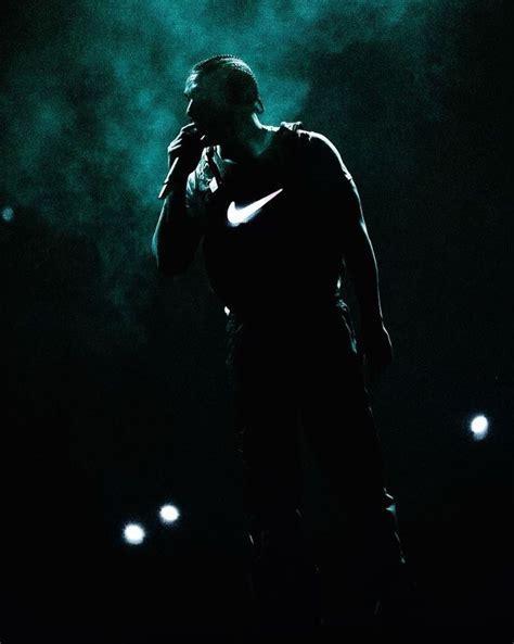 a man standing in the dark talking on a cell phone