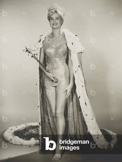 Image of Marlene Schmidt, Miss Universe 1961, holds a scepter, wears a