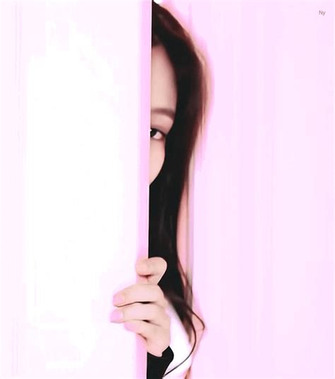 a woman peeking out from behind a wall