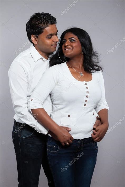 Young romantic indian couple. Wearing white shirt and jeans. Stu ...