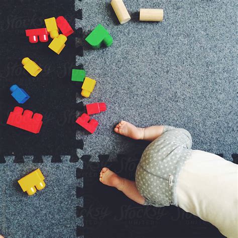 Baby crawling from assorted infant toys. by Lucas Saugen - Scattered ...