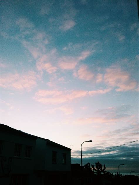 the sky is pink and blue at dusk with clouds in the foreground, some ...