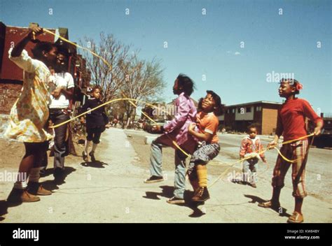 Several black children are playing jump rope outside of the Ida B Wells Homes, one of Chicago's ...