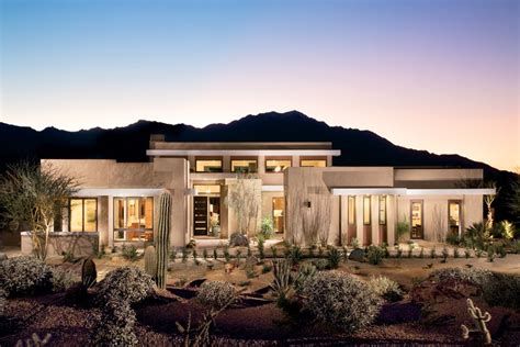 a desert home with cactus and cacti in the front yard at night time