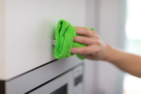 Person using a damp cloth to dust their home.