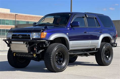 a blue suv parked in front of a building