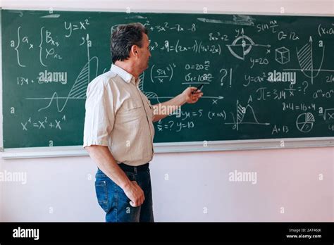 Teacher pointing to the blackboard and explain a lesson.- Image Stock ...