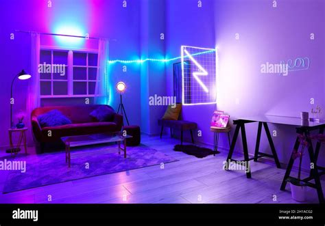 Interior of stylish living room with neon lighting Stock Photo - Alamy