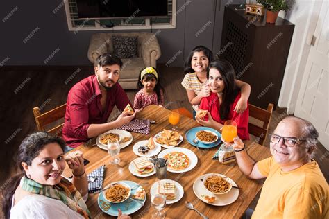 Premium Photo | Indian Family eating food at dining table at home or ...