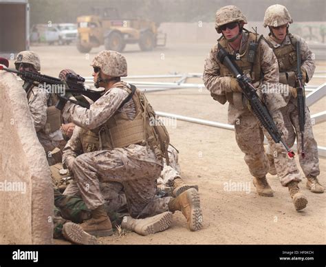 A squad with 2nd Battalion, 3rd Marines, find cover behind a wall ...