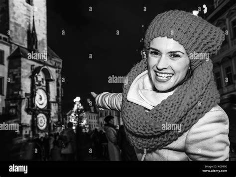 Magic on streets of the old town at Christmas. smiling young traveller woman in red hat and ...