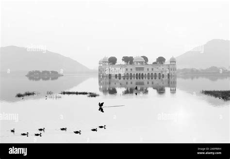 Empty Royal palace surrounded by lake and Aravalli hills as backdrop at sunrise in Jaipur ...